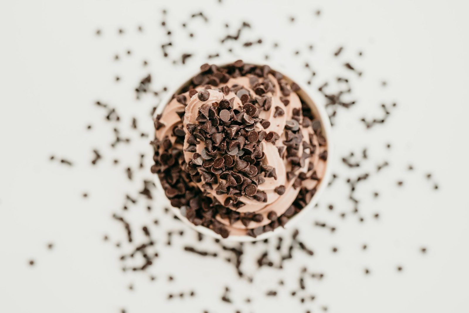 Overhead view of frozen yogurt with chocolate toppings